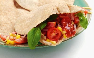 Pitabrød med skinke, tomat, mais og basilikum