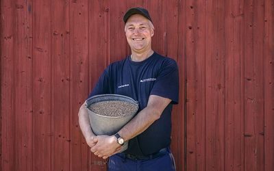 Bonde Ole Einar Amlie med en bøtte såkorn