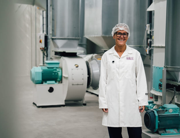 Marianne Aareskjold foran møllemaskineriet som maler norsk korn til mel