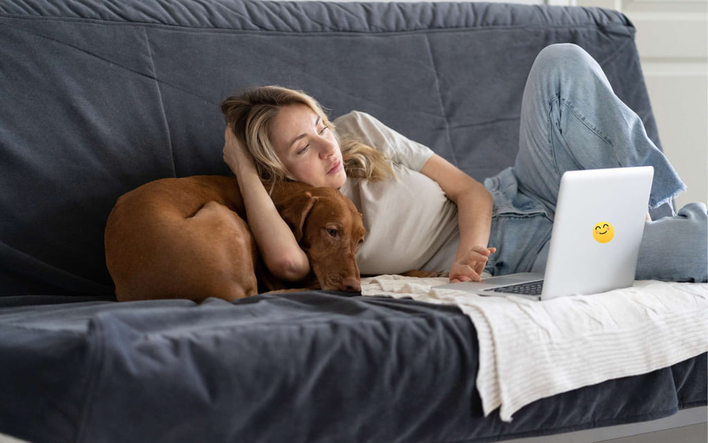 Dame og hund som hviler på sofa