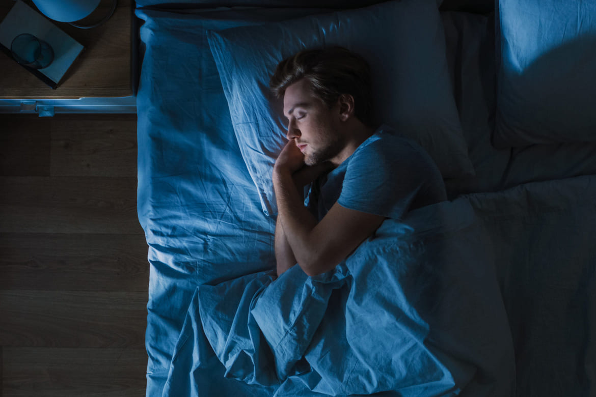 Tanngnissing_herobilde_behandling Mann som sover i sin seng. De fleste gnisser tenner når de sover.