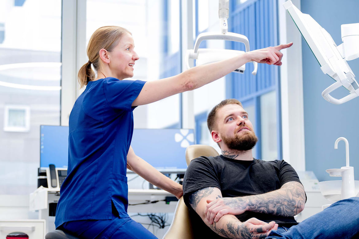 Tannlege forklarer for pasient