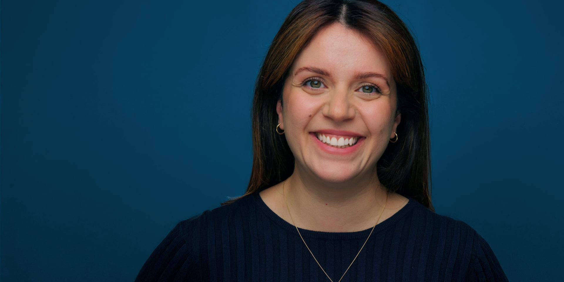 Smilende dame med kjede og ringer i ørene