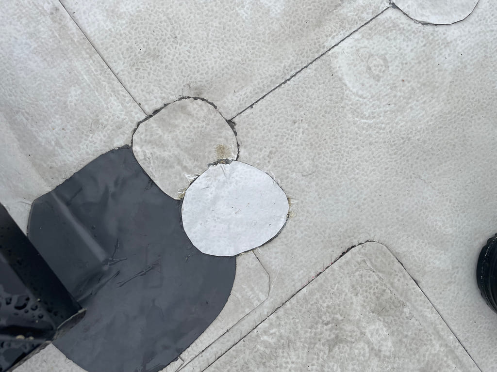 Eksempel på feil utført takreparasjon med PVC-belegg: Ujevne skjøter, manglende avslutninger og dårlig tilpasning rundt gjennomføringer. Bildet illustrerer konsekvensene av ufagmessig arbeid og viser hvorfor profesjonell utførelse er viktig for tetthet og levetid.