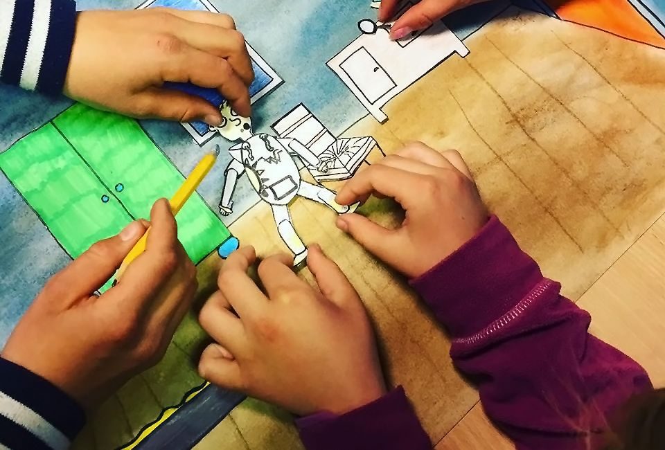 Barnehender leker med utklippsfigurer.