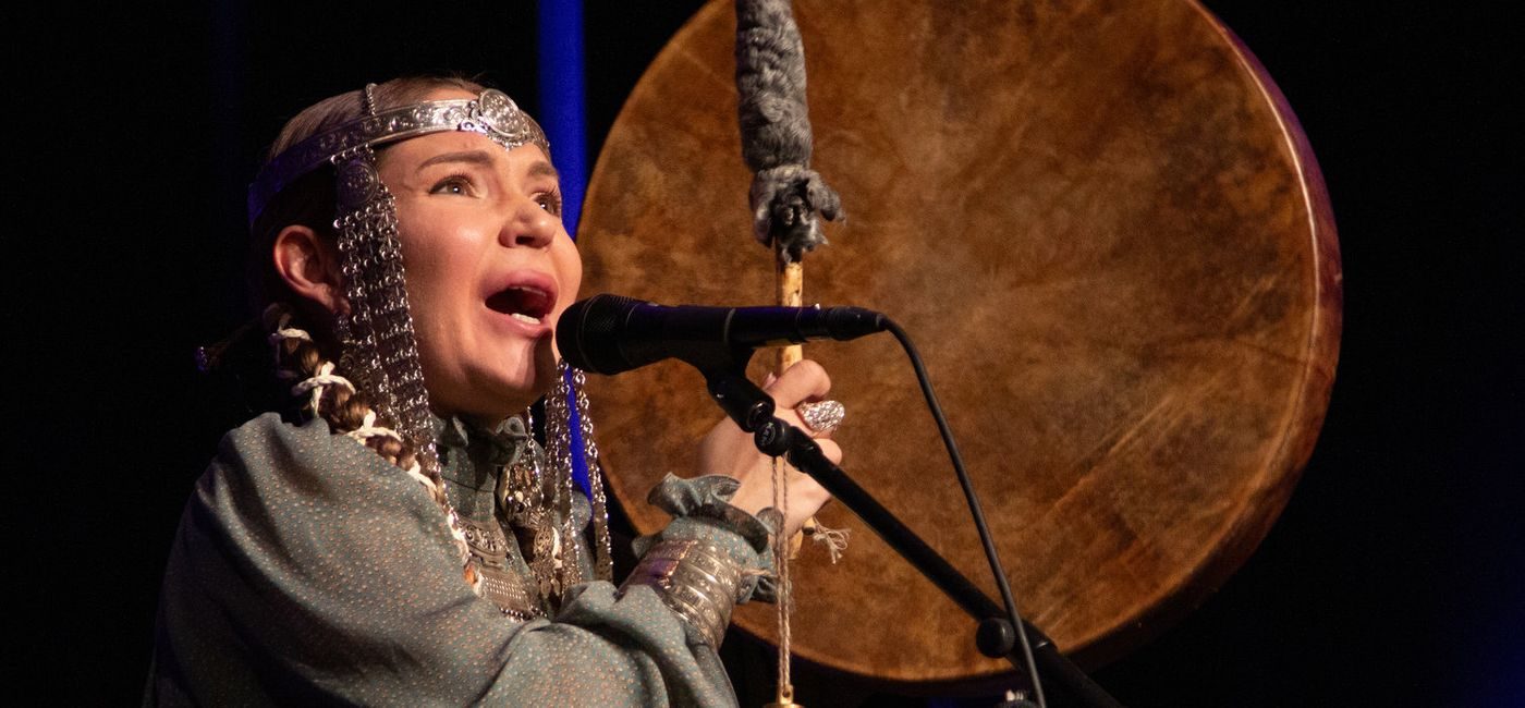 Kvinne i kostyme synger på scenen