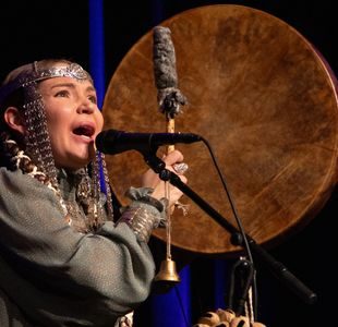 Kvinne i kostyme synger på scenen