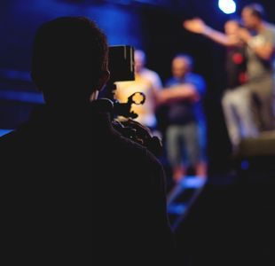 Mann filmer personer på en scene.
