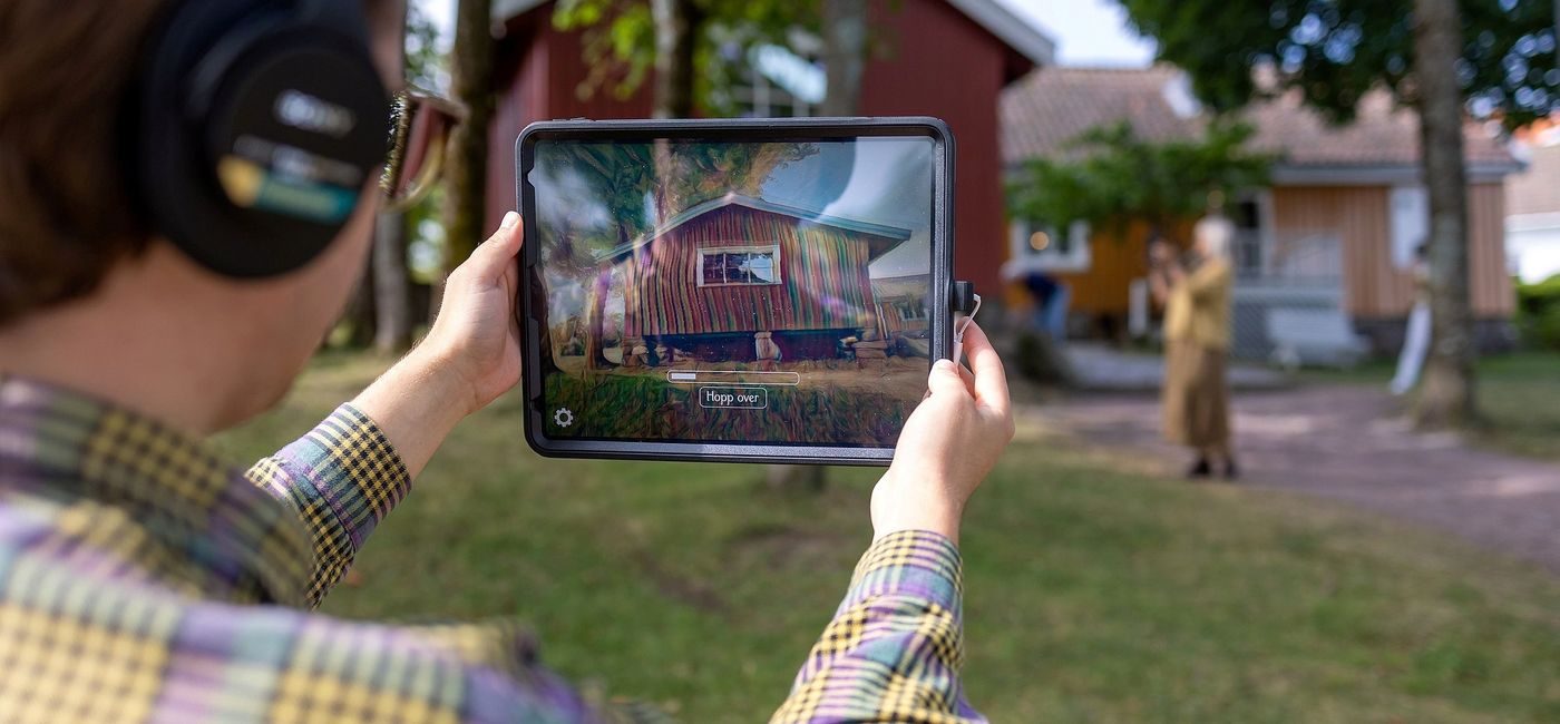 Person med nettbrett og hodetelefoner tester "Munchs digitale hage"