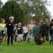 En gruppe elever går etter en person kledd i kamuflasje