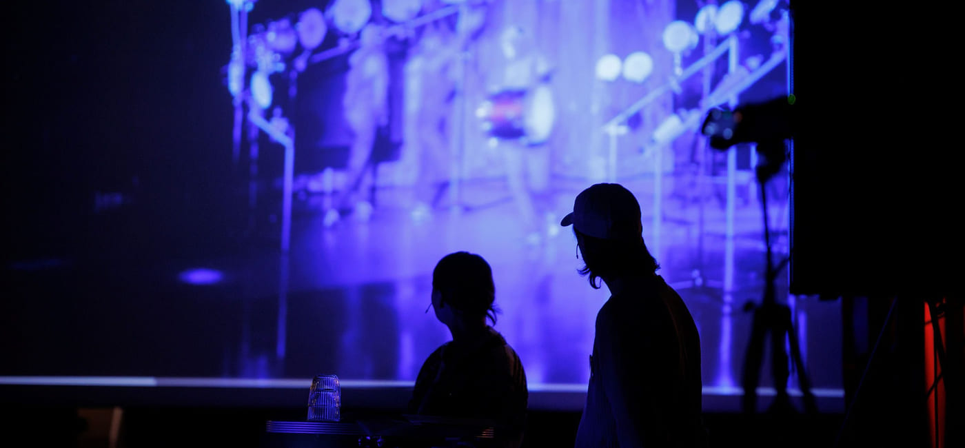 To personer i silhuett foran et lerret