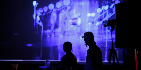 To personer i silhuett foran et lerret