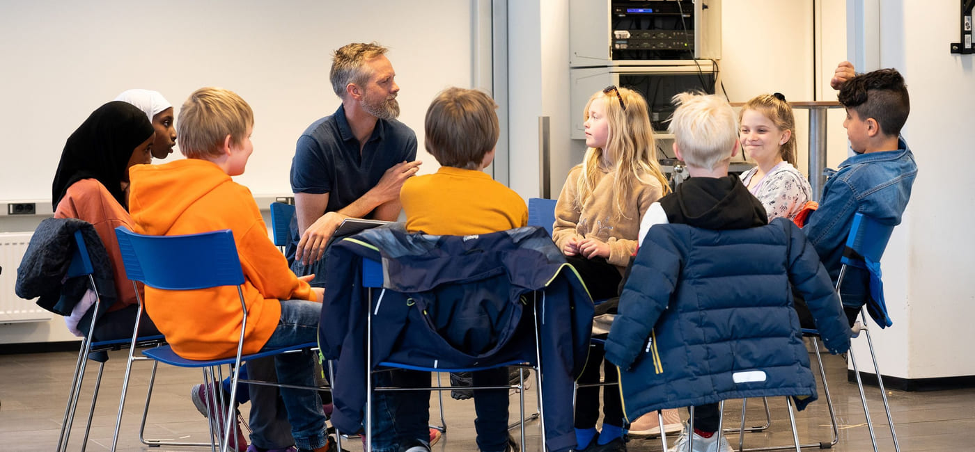 Forfatter Bår Stenvik og en gruppe elever sitter i en sirkel og prater sammen