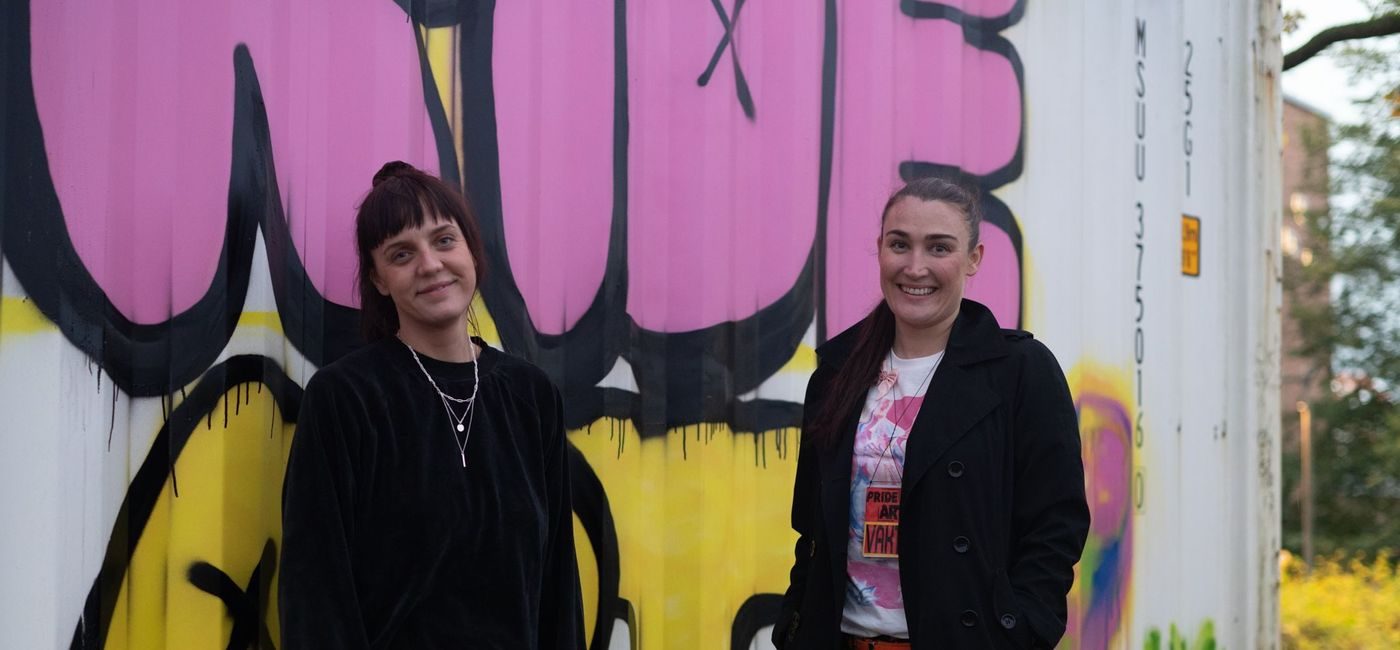 to unge kvinner står foran en container som er spraylakkert