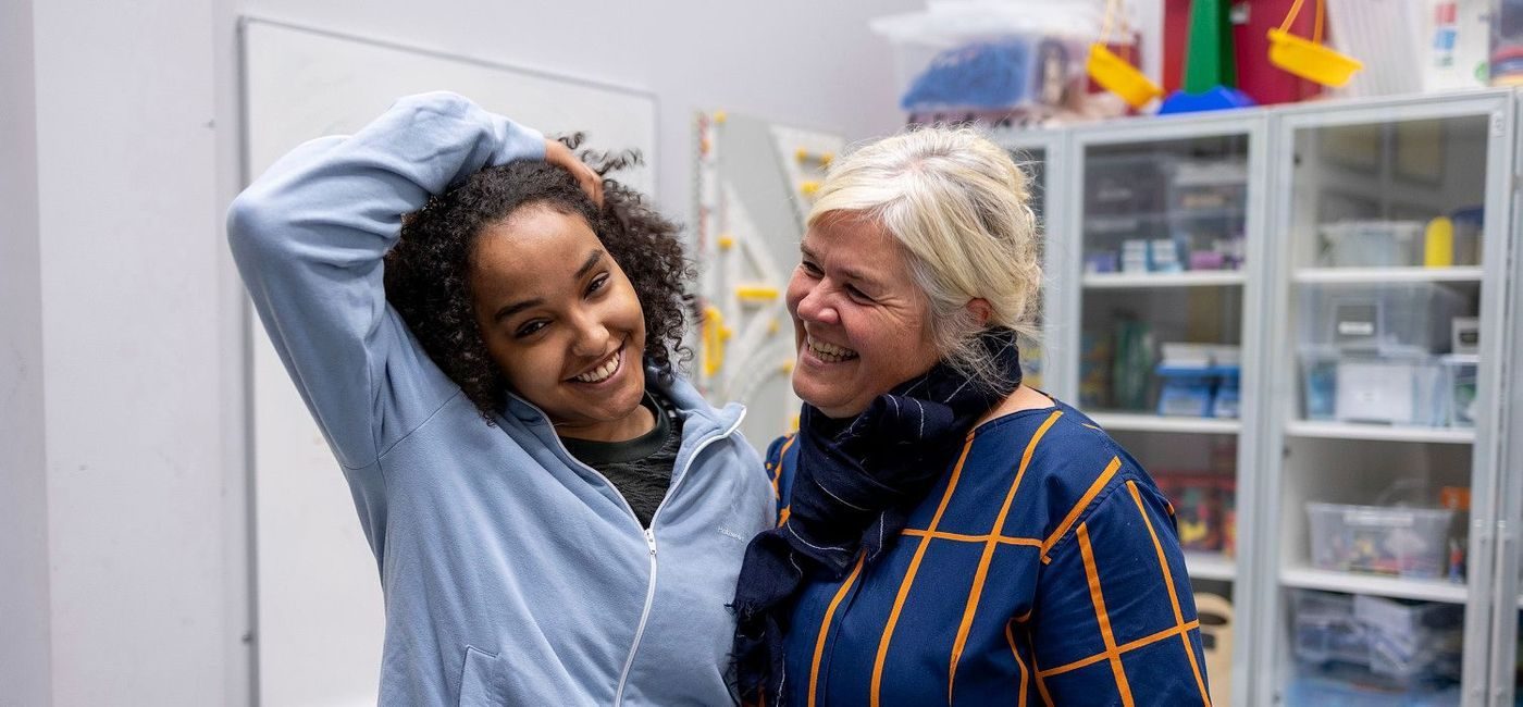 En ung og en eldre kvinne holder rundt hverandre og smiler