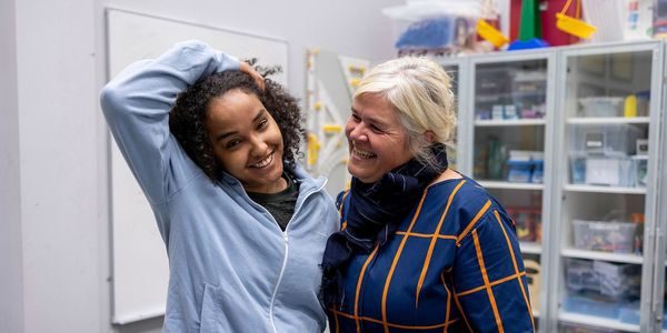 En ung og en eldre kvinne holder rundt hverandre og smiler