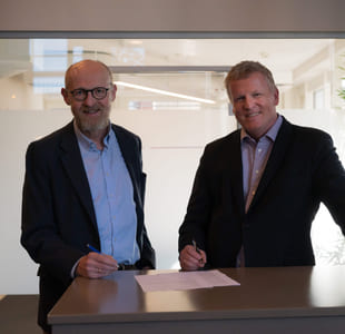 To menn står ved et bord