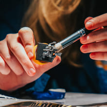 To hender arbeider med loddebolt og små elektroniske komponenter i et teknologiprosjekt.