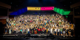 Veldig mange mennesker ser i kamera. De er stilt opp på et fellesbilde