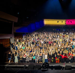 Veldig mange mennesker ser i kamera. De er stilt opp på et fellesbilde