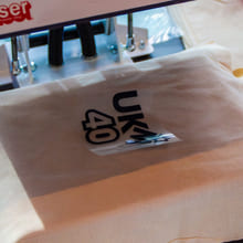 Et stykke stoff blir dekorert med trykk av et motiv i en kreativ håndverksaktivitet.