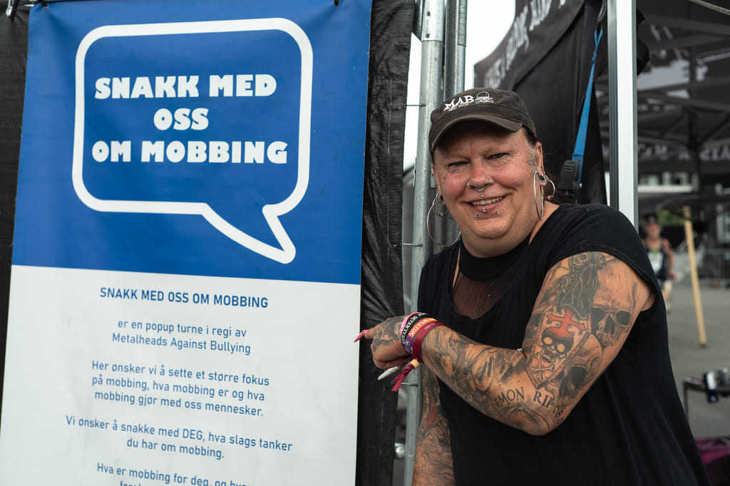 Mann peker på plakat som markerer kampanje mot mobbing.