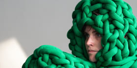 En dame ser til venstre. På hodet og foran seg har hun irrgrønne tau.