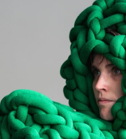 En dame ser til venstre. På hodet og foran seg har hun irrgrønne tau.