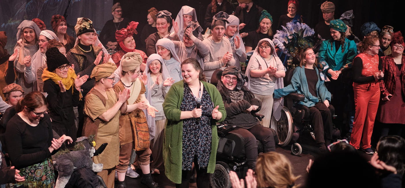 Stor gruppe mennesker samlet på scenen.