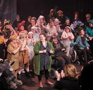 Stor gruppe mennesker samlet på scenen.