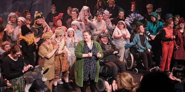 Stor gruppe mennesker samlet på scenen.