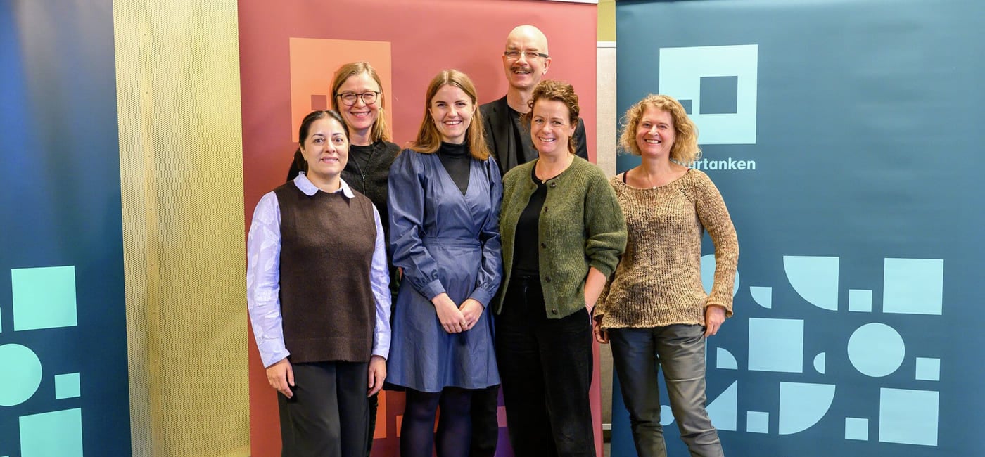 Gruppebilde av fem personer. De står foran tre fargrike roll-ups i Kulturtankens farger.