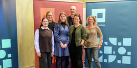 Gruppebilde av fem personer. De står foran tre fargrike roll-ups i Kulturtankens farger.