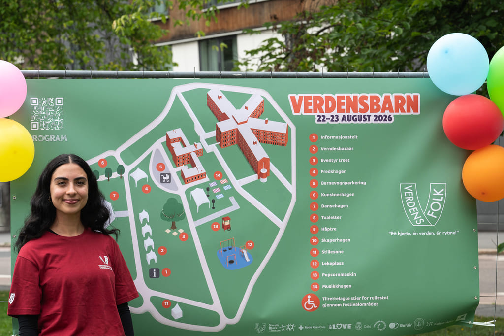 En person står foran informasjonsskilt med kart over festivalområdet til Verdensbarn.