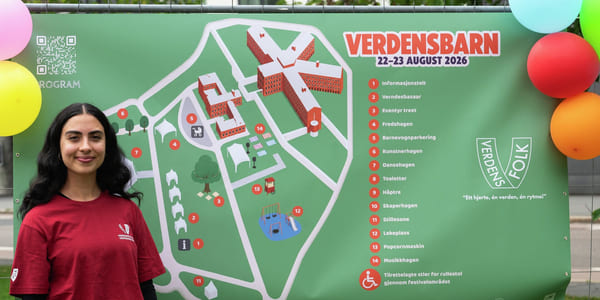 En person står foran informasjonsskilt med kart over festivalområdet til Verdensbarn kulturfestival.
