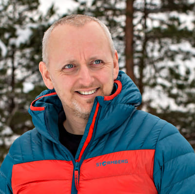 Inkluderende arbeidsliv: Blid mann i boblejakke ser til siden.