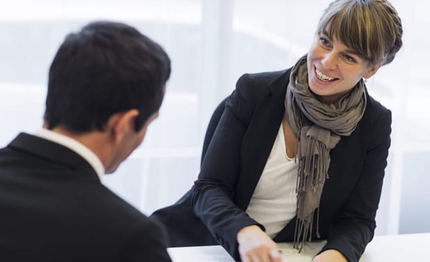 Sluttsamtale: En blid kvinne i samtale med en mann med ryggen til.