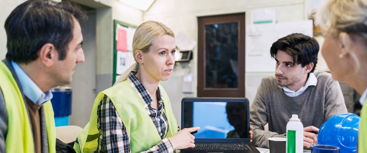 Agilt: En gruppe kolleger sitter rundt et bord med en PC, to kvinner og to menn.