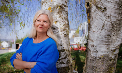 Krise: Kvinne står lent mot en bjørketre. Til sak om ledertips i koronatider