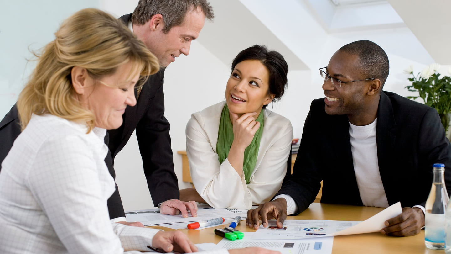 Motivasjon: Fire kolleger, to kvinner og to menn, har en hyggelig prat på jobben.