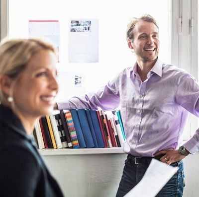 Smart: En mann og en kvinne står smilende i et kontor.