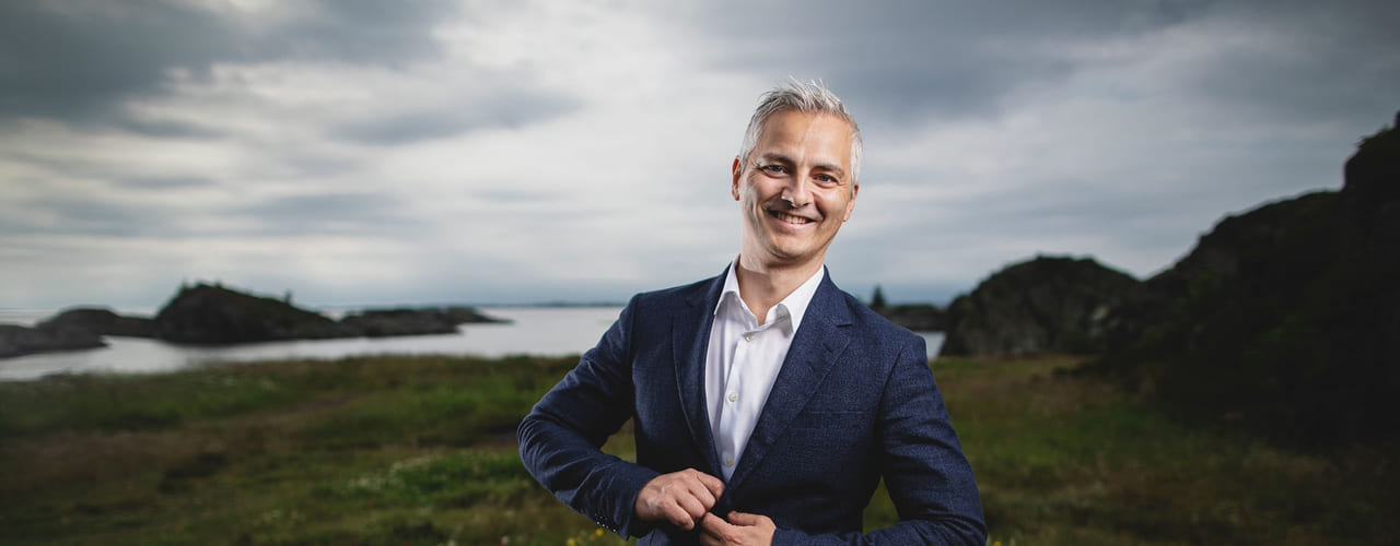 Kroppsspråk: Blid mann med en selvsikker mine står ute i et vakkert landskap .