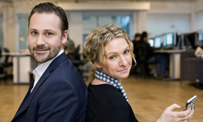 Personligheten: En mann og en kvinne sitter rygg mot rygg og ser i kameraet.