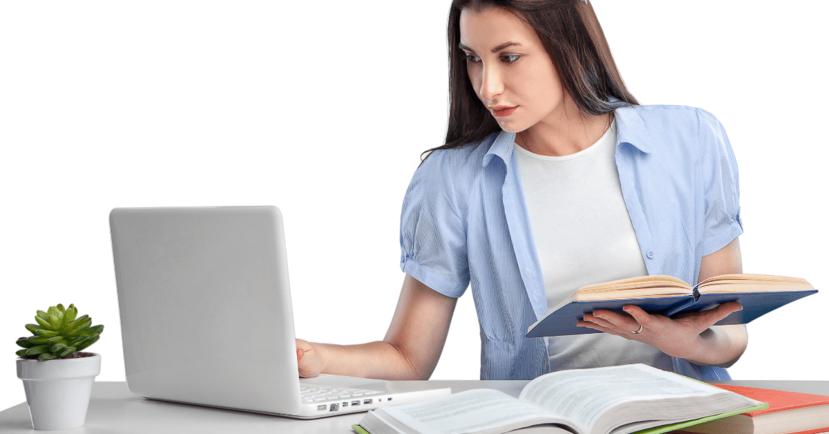 Dame som slår opp i bøker og på laptop