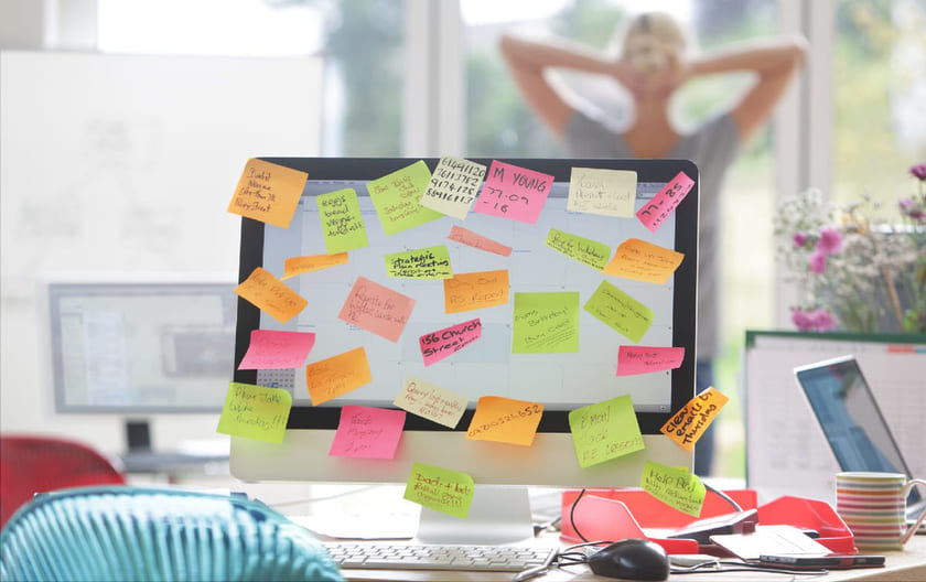 Dataskjerm med mange post-its, illustrerer mange oppgaver og behovet for å prioritere