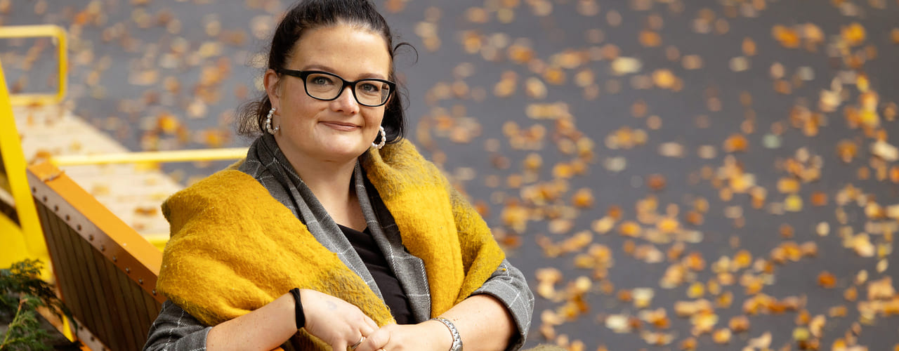 Carina Haugsdal sitter på en benk og ser inn i kamera