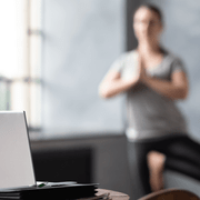 En dame som står i yogaposisjon på kontor