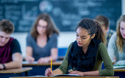 Illustrasjonsfoto av elever som sitter og skriver eksamen. Foto: Istock.