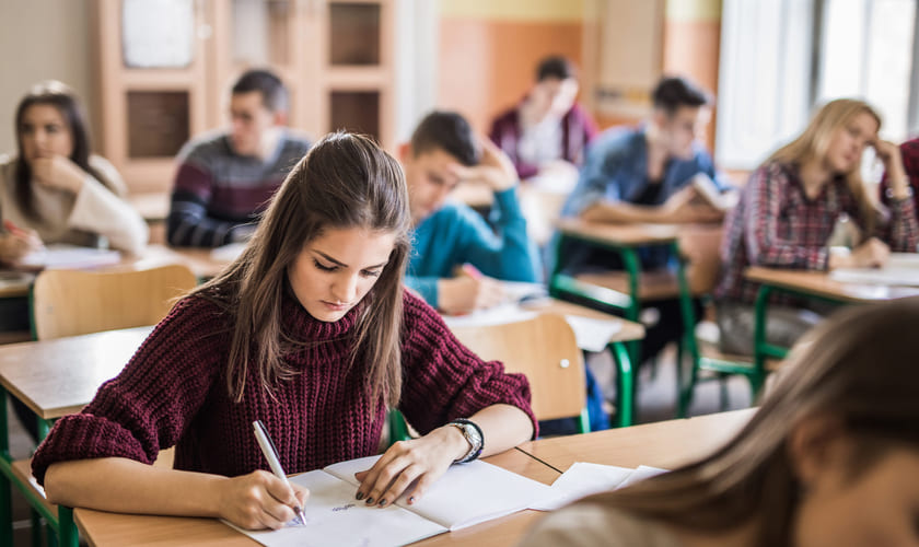 Illustrasjonsbilde av videregående-elever i et klasserom som har en skriftlig prøve. Foto: Istock.