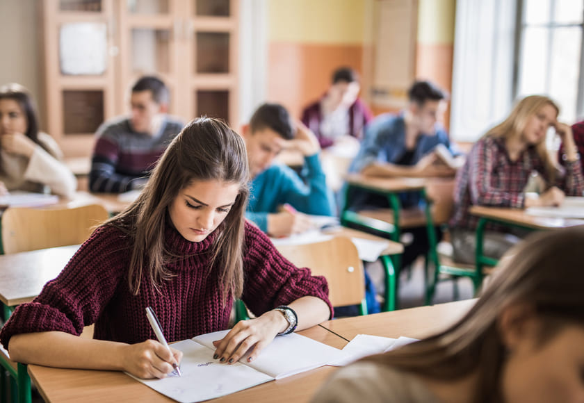 Illustrasjonsbilde av videregående-elever i et klasserom som har en skriftlig prøve. Foto: Istock.